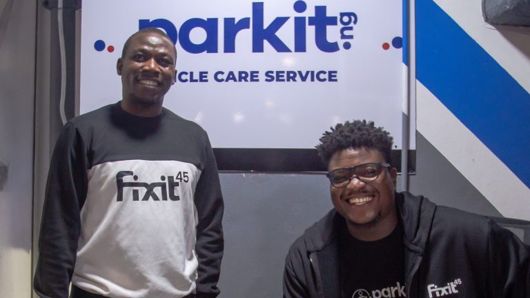 Two men standing in front of a sign that says Parkit eCycle Care Service.