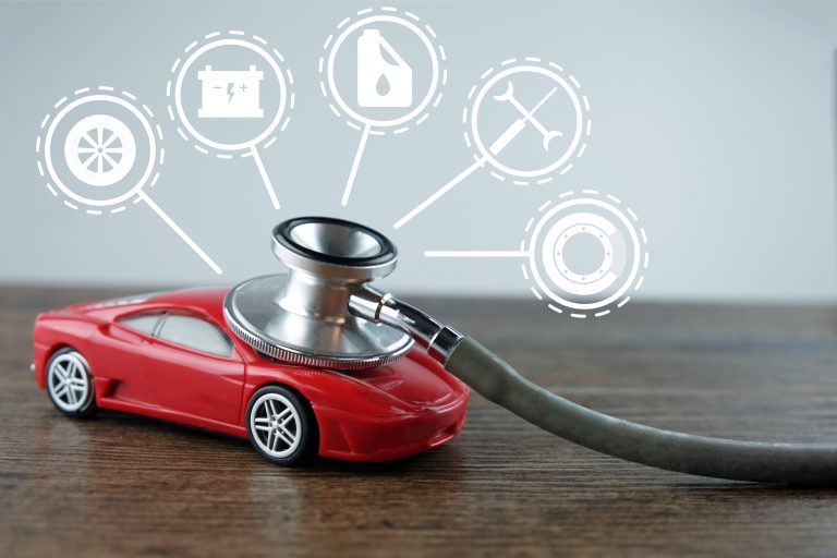 A stethoscope is placed on a toy car with icons representing a battery, oil, tools, and a tire, symbolizing car diagnostics and maintenance.